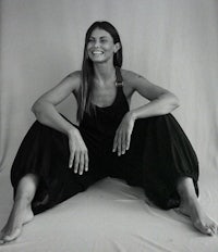 a black and white photo of a woman sitting on the floor